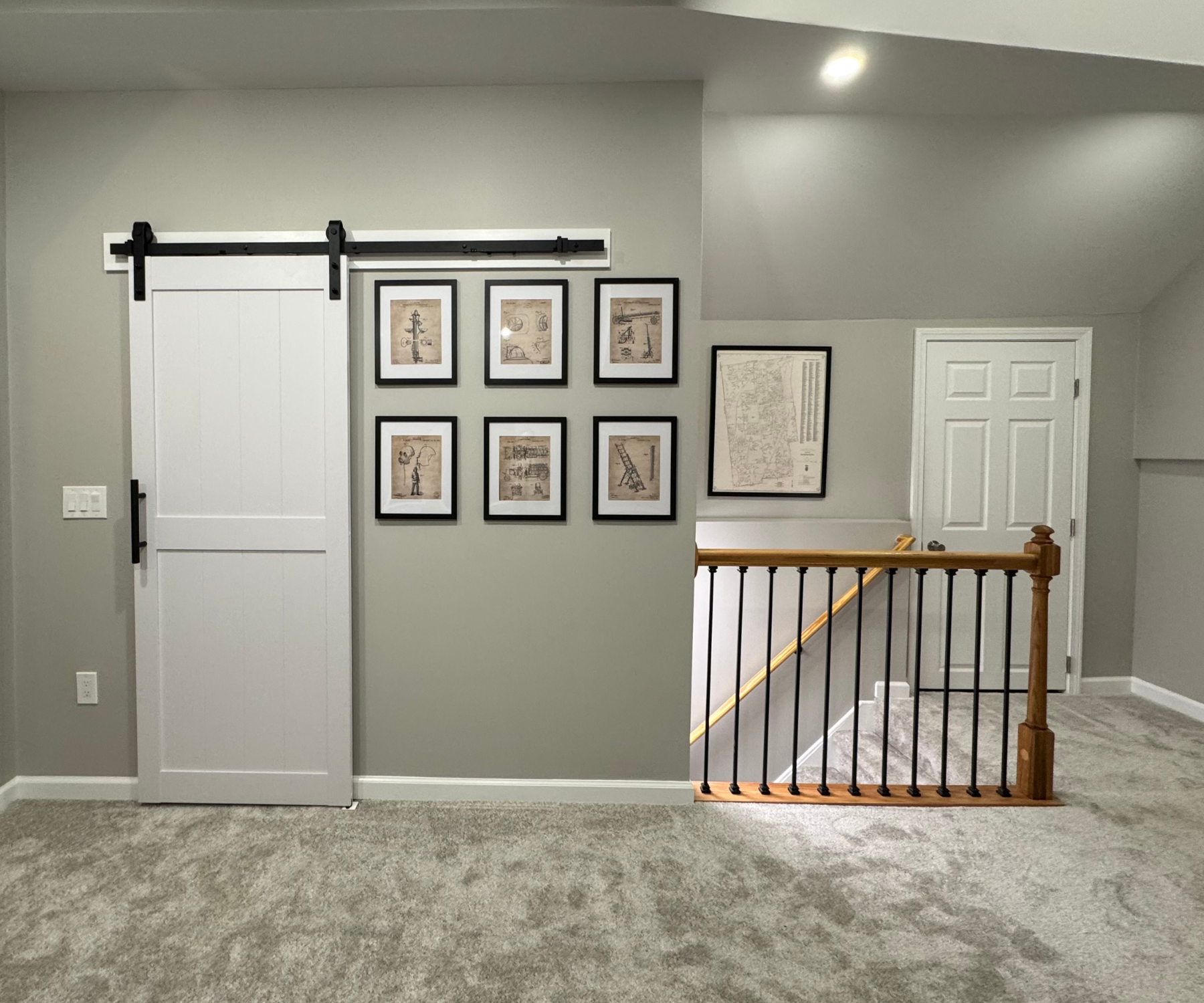 Renovated upstairs space with barn-style sliding door and modern railing